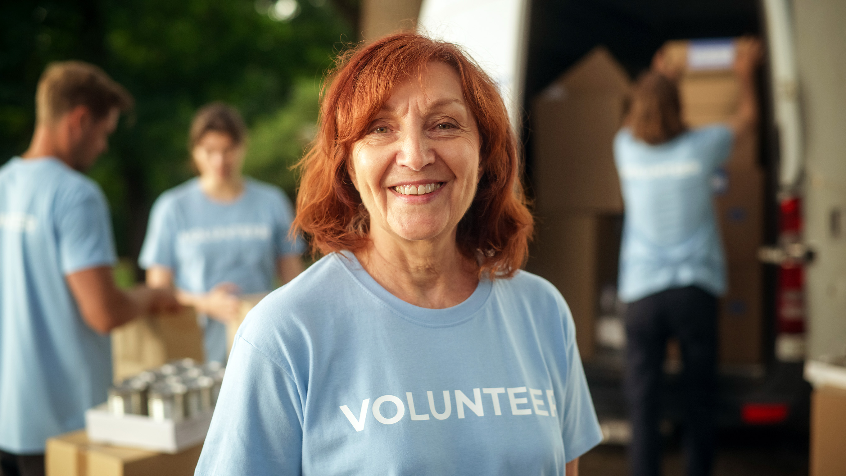 woman wearing volunteer t-shirt with other volunteers in background