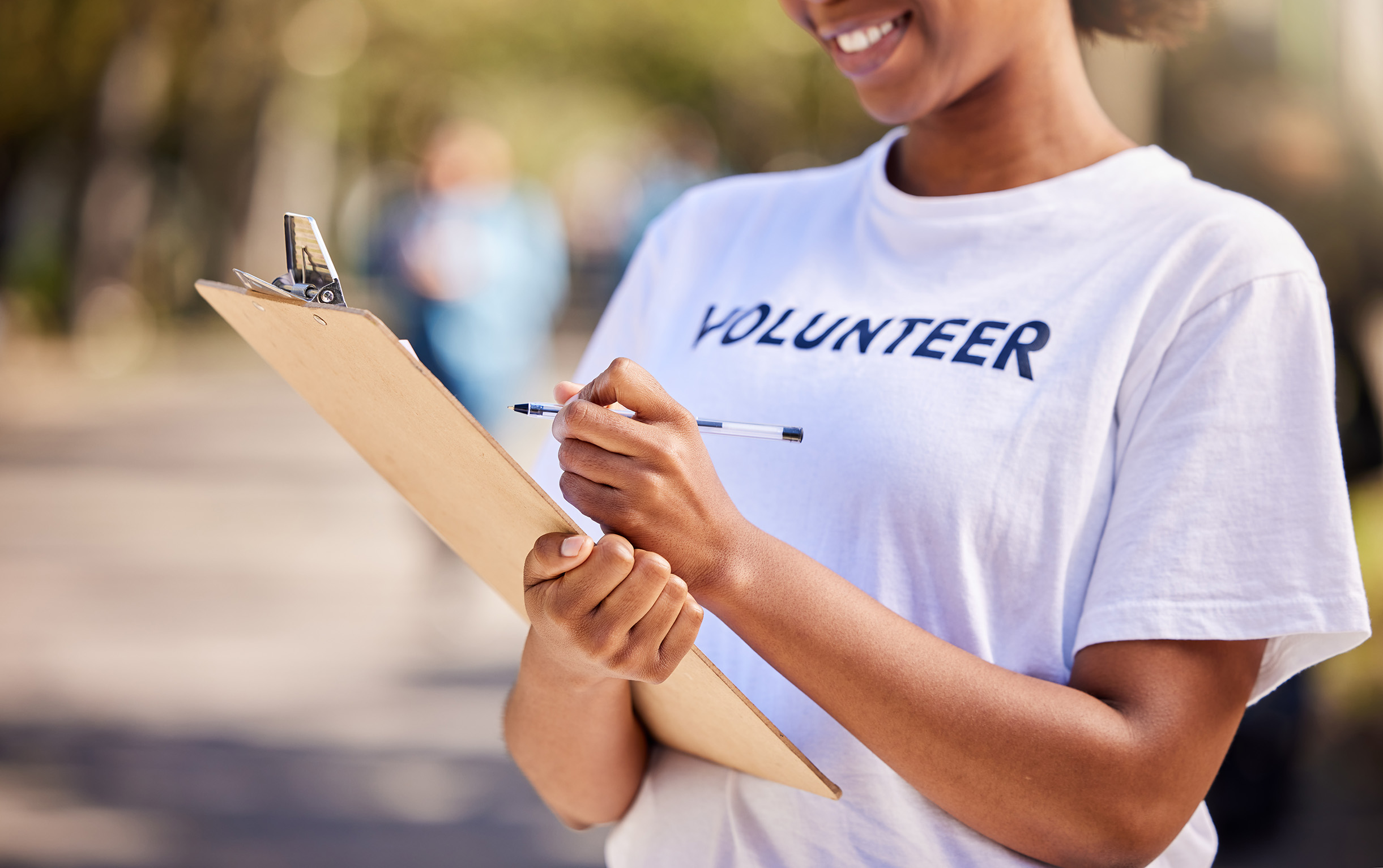 woman wearing volunteer t-shirt holding a clipboard