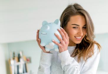 woman shaking a piggy bank