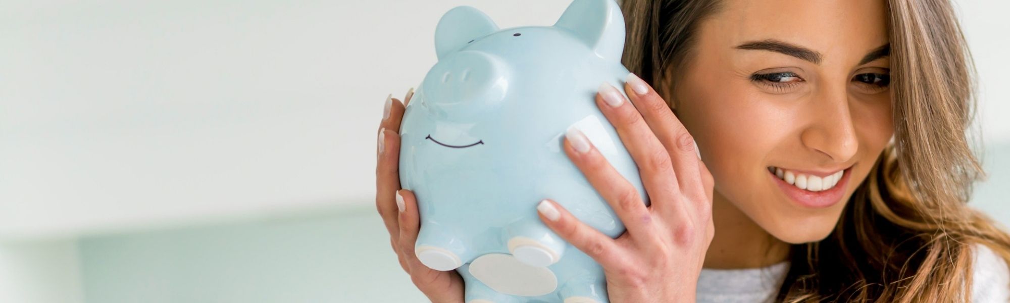 woman shaking a piggy bank