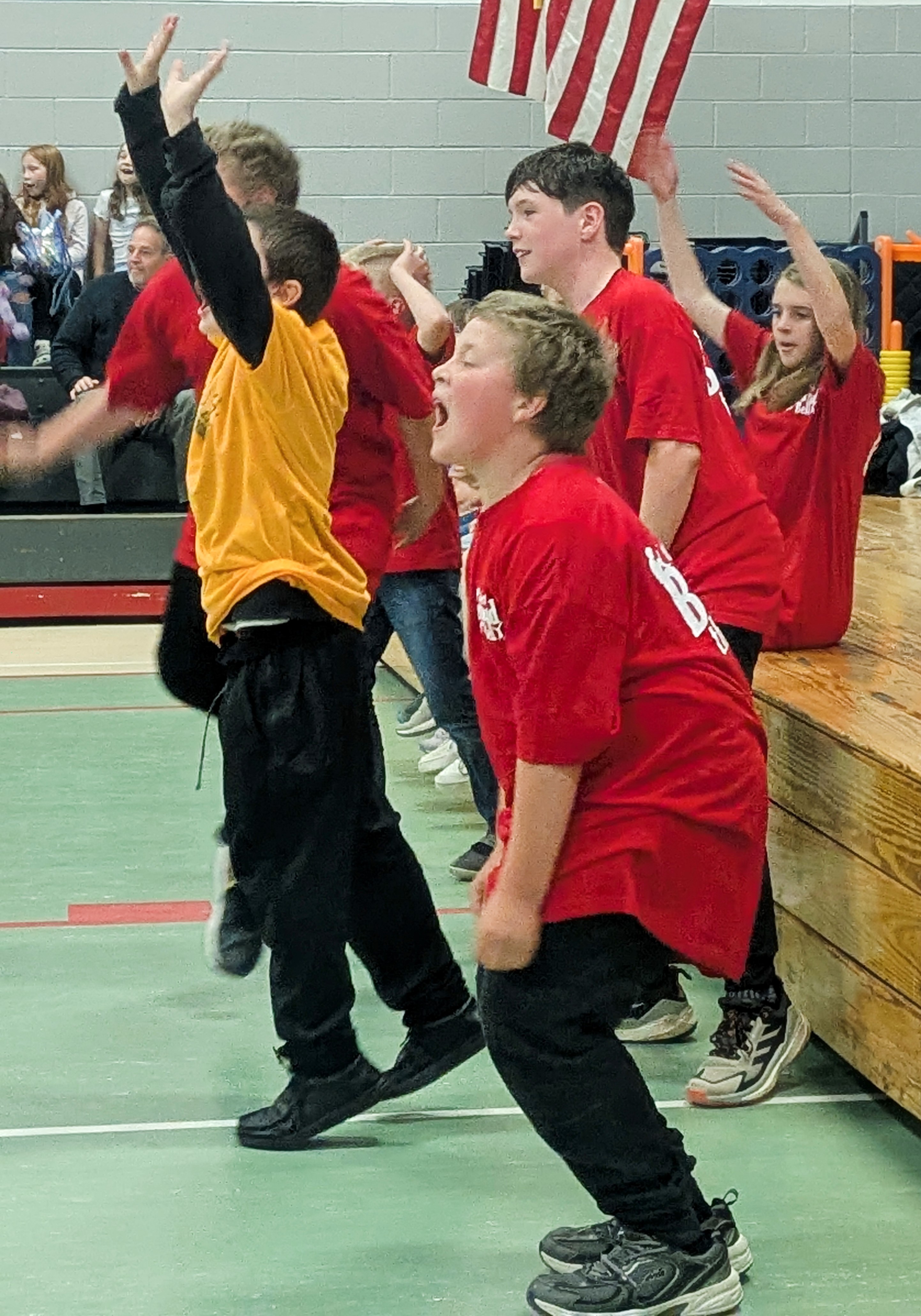school children cheering in gymnasium