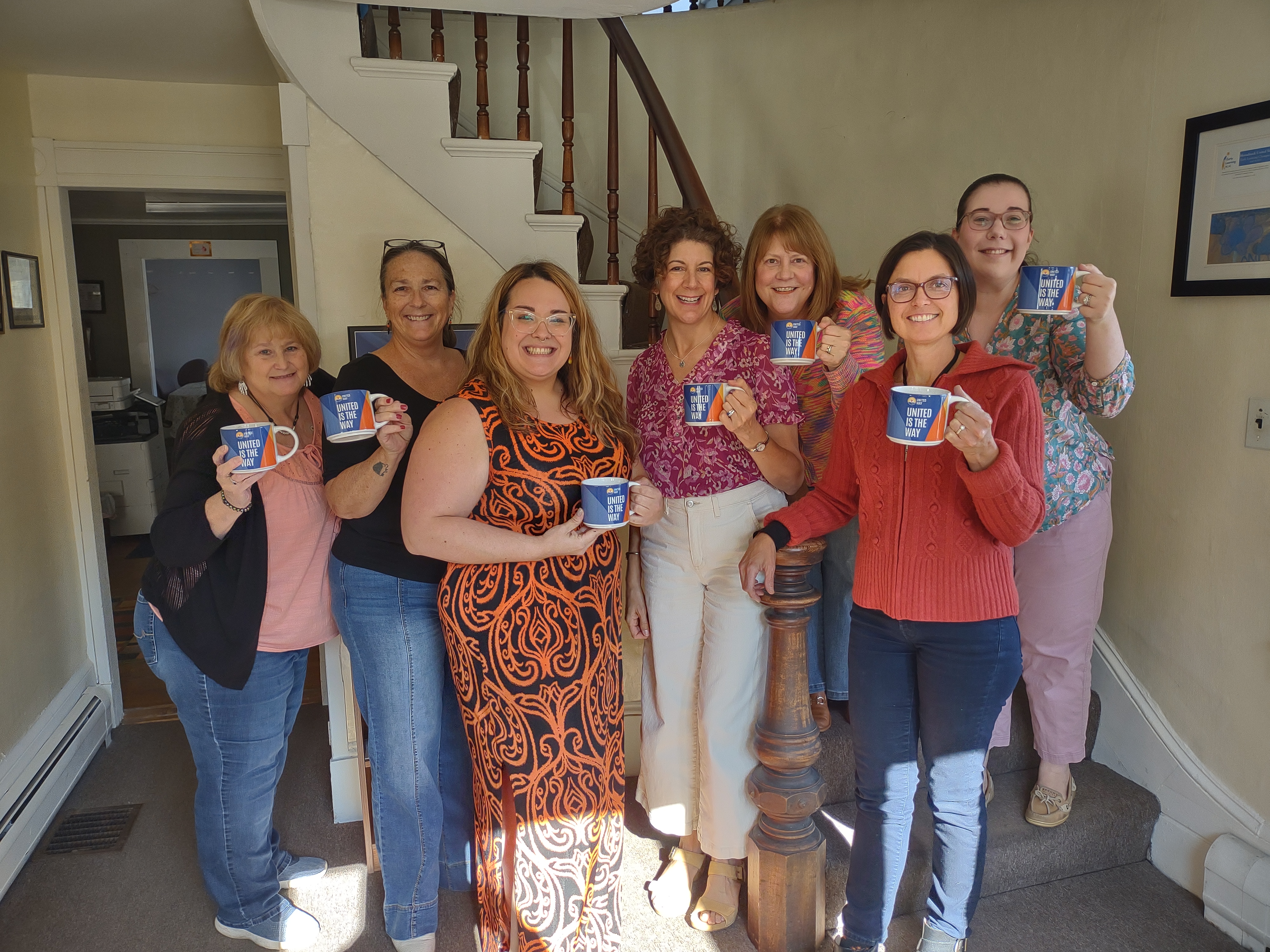 muw staff members holding the newly rebranding united way mugs