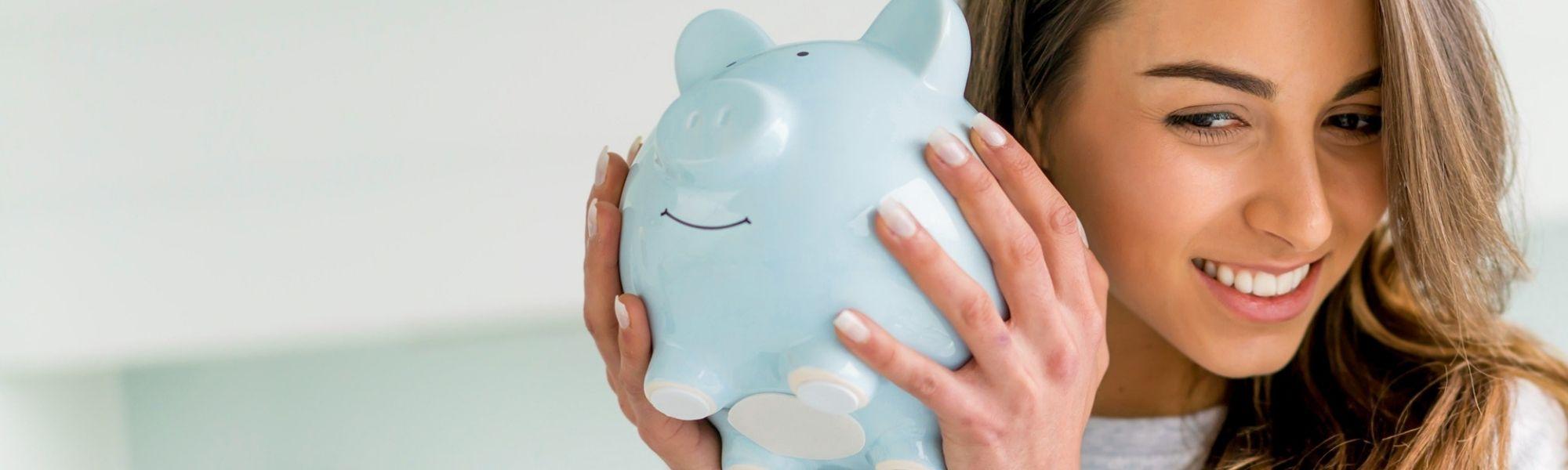 woman shaking a piggy bank
